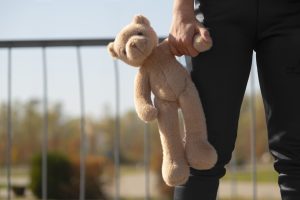 front-view-kid-holding-teddy-bear-outdoors